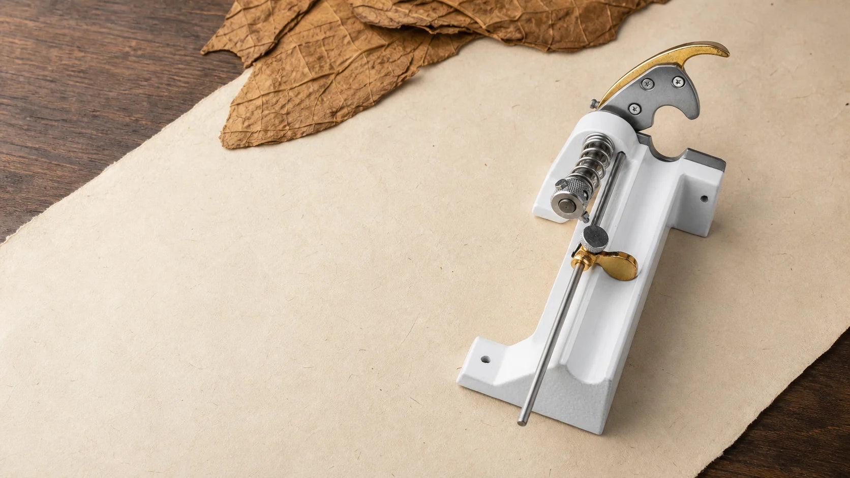 Professional cigar tuck cutter arranged on cream work paper and walnut